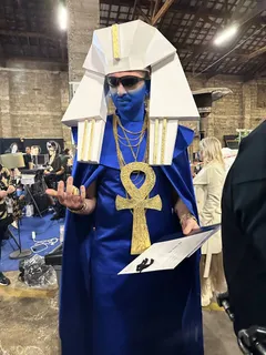 Costume for Osiris combining a Rick Owens runway-inspired headpiece with Schiaparelli-inspired makeup and an oversized ankh chain, giving the Egyptian god the attitude of a 1990s rapper. Costume design by Olya Chuk.