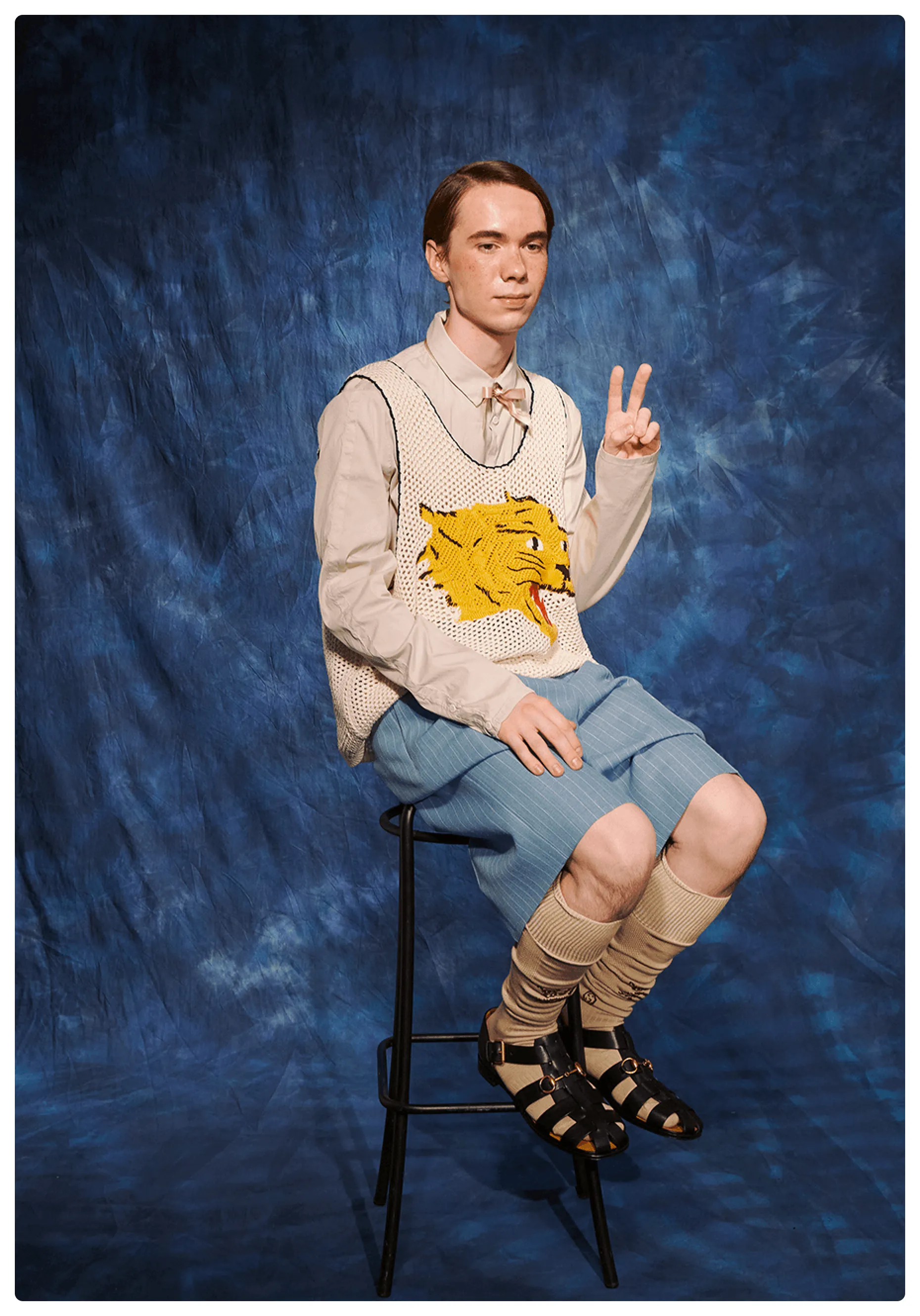 Young actor portrayed as the class nerd in a school yearbook, wearing a full Gucci look by Alessandro Michele.