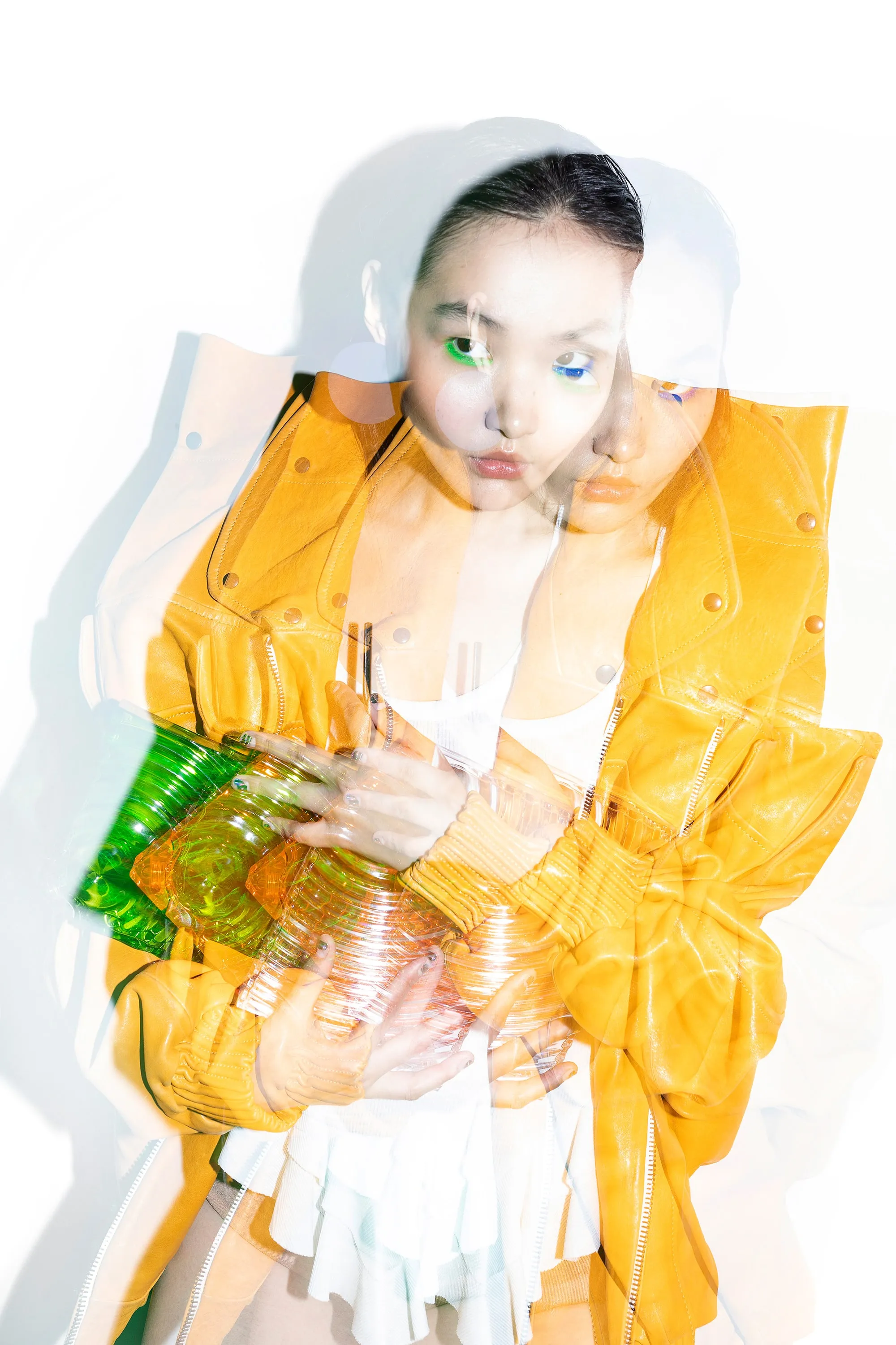 Model wearing pieces by independent designers, including a yellow jacket with exaggerated shoulders and a peplum top styled as a dress.