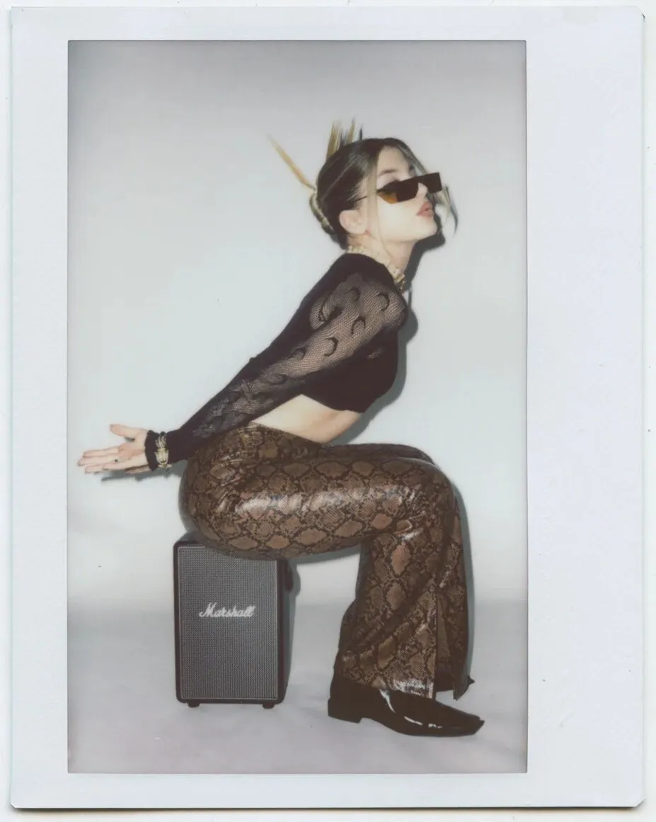 Blogger photographed on Instax for a Vogue × Instax advertorial, wearing Y2K-inspired snakeskin leather trousers.