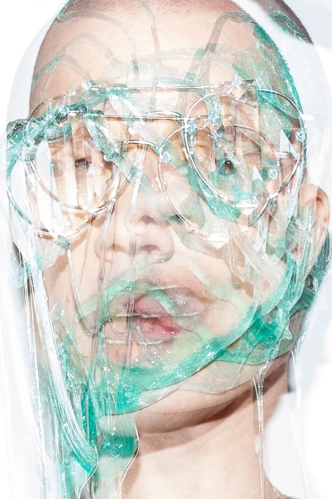 Model wearing Tom Ford glasses with translucent slime covering the face.