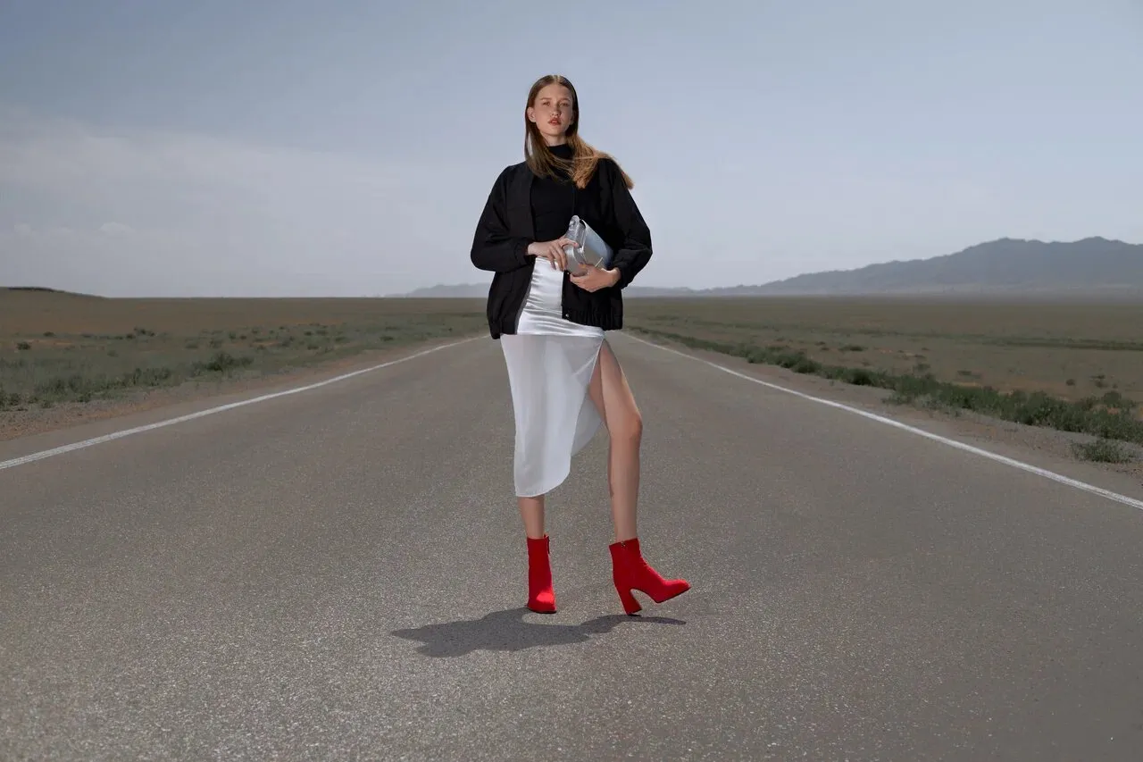 Commercial footwear campaign featuring a model on an open road, with styling inspired by the Prada collection of the same season.