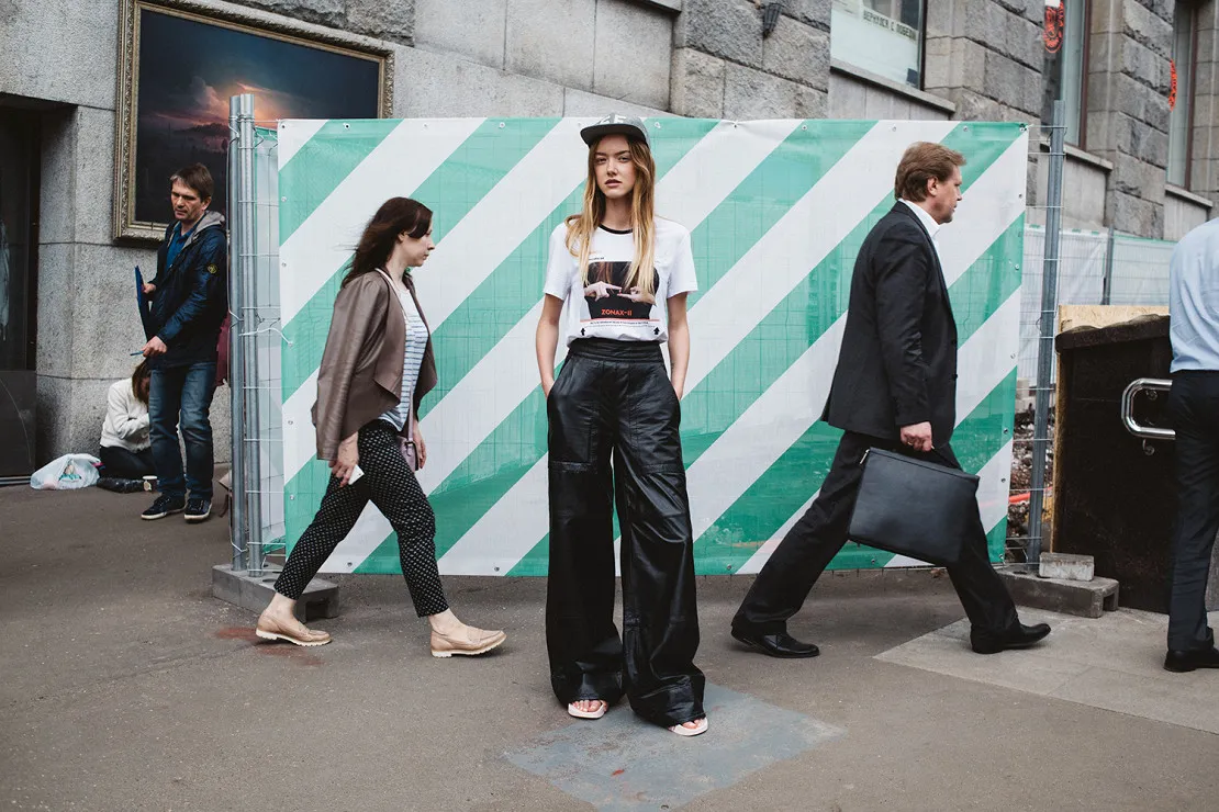 Model wearing a Gosha Rubchinskiy top in central Moscow, standing still as pedestrians move around her in an editorial about prolonged construction in the city centre.